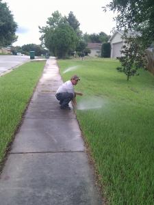 a Richardson Sprinkler Repair tech adjusts a sprinkler line