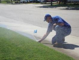 Richardson sprinkler repair specialist adjusts a Hunter pop up head during testing